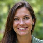 Portrait of Dr. Elara Vance, a lead naturalist, smiling confidently in field gear.