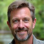 Portrait of Mark Harrison, a government biologist with field gear, looking professional and experienced.