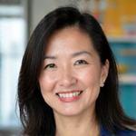 Portrait of Sarah Chen, an NGO conservation leader, smiling confidently.